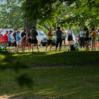 adults standing in a circle outside